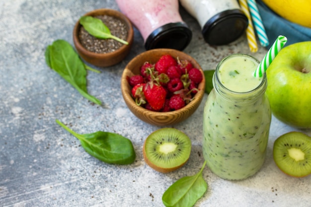 Le concept d'une alimentation saine. Mélange de smoothies détoxifiants. Smoothies verts smoothies aux fruits et légumes sur un plan de travail en béton de pierre. Copiez l'espace.