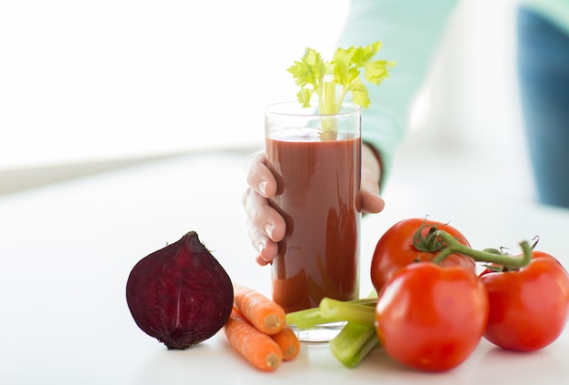 concept d'alimentation saine, de nourriture, de régime et de personnes - gros plan sur des mains de femme avec du jus de tomate et des légumes