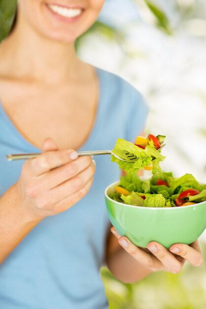 concept d'alimentation saine et de régime - femme mangeant de la salade avec des légumes