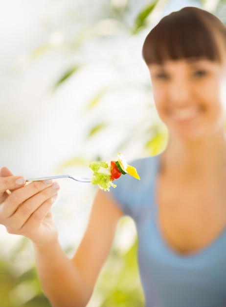 concept d'alimentation saine et de régime - main de femme tenant une fourchette avec des légumes