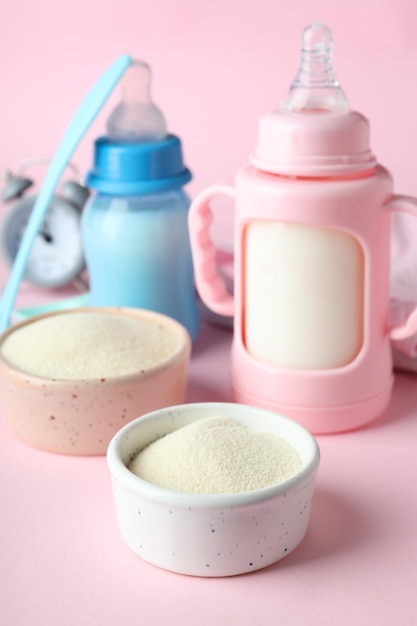 Concept d'aliments pour bébés avec du lait en poudre sur fond rose