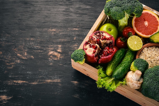 Le concept d'aliments sains Légumes frais noix et fruits dans une boîte en bois Sur un fond en bois Vue de dessus Espace de copie