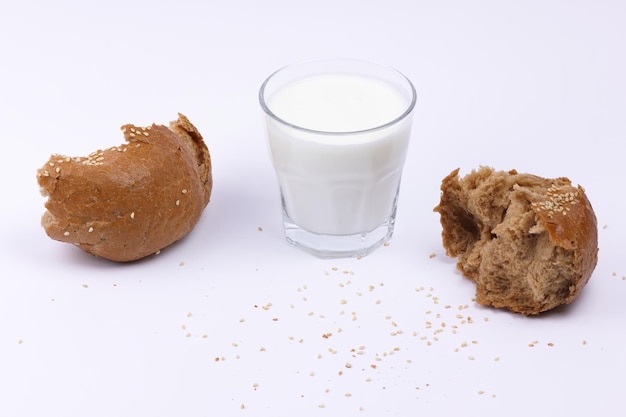 Concept d'aliments sains Verre transparent complet de lait blanc avec des tranches de pain de seigle isolé sur fond blanc Nourriture pour une collation saine