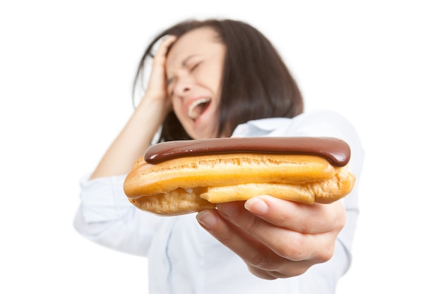 Concept d'aliments santé. Belle jolie jeune femme refusant de manger des éclairs au chocolat sur fond blanc