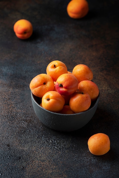 Concept d'aliments végétaliens sains avec des abricots sucrés dans un fond sombre,