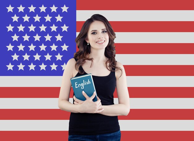 Concept américain avec un portrait d'étudiante assez heureuse contre le fond du drapeau des États-Unis d'Amérique Voyage et apprenez la langue anglaise