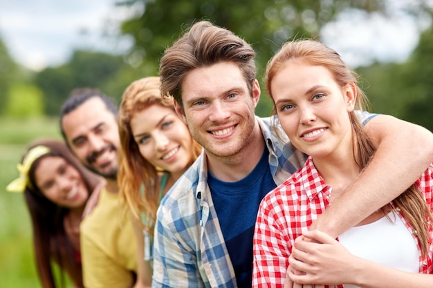 concept d'amitié, de loisirs, d'été et de personnes - groupe d'amis souriants à l'extérieur