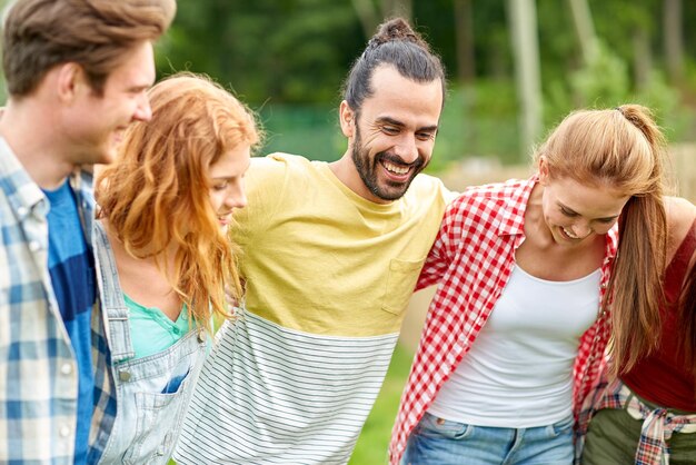 concept d'amitié, de loisirs, d'été et de personnes - groupe d'amis souriants à l'extérieur