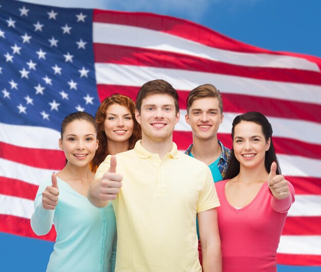 concept d'amitié, de patriotisme et de personnes - groupe d'adolescents souriants debout sur fond de drapeau américain