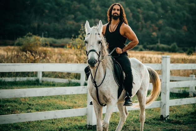 Concept d'amour équestre et animal cavalier sur cheval arabe gris dans le domaine bel homme barbu débarrasser