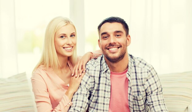 concept d'amour, de famille et de bonheur - couple heureux souriant à la maison