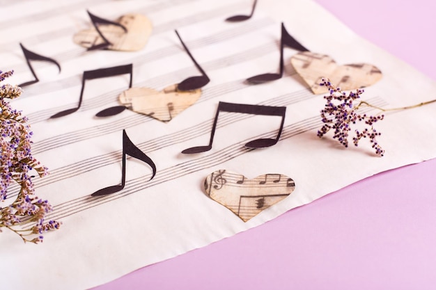 Le concept de l'amour pour la musique Notes de papier et coeurs sur une feuille de musique