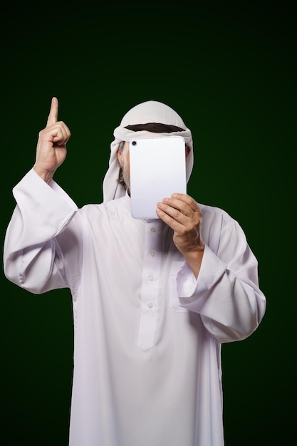 Photo concept anonyme musulman personne arabe est titulaire d'une tablette numérique couvert l'index jusqu'à représentant