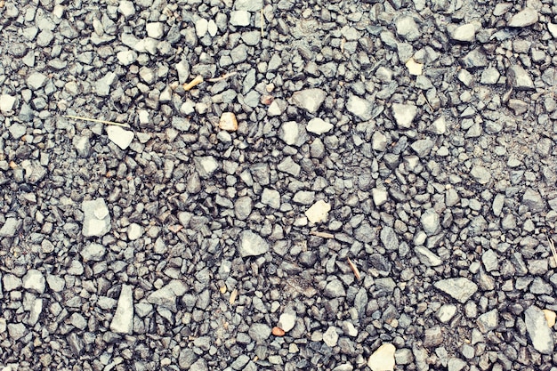 concept d'arrière-plan et de texture - gros plan de pierres de macadam gris sur le sol