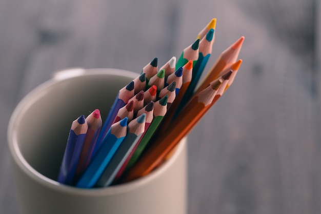 Concept artistique, beaucoup de crayon dans une tasse sur une table en bois