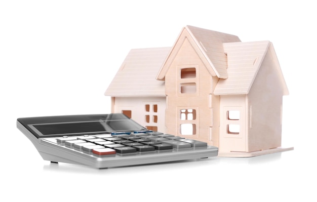 Concept d'assurance maladie Maison de jouets en contreplaqué avec calculatrice sur fond blanc