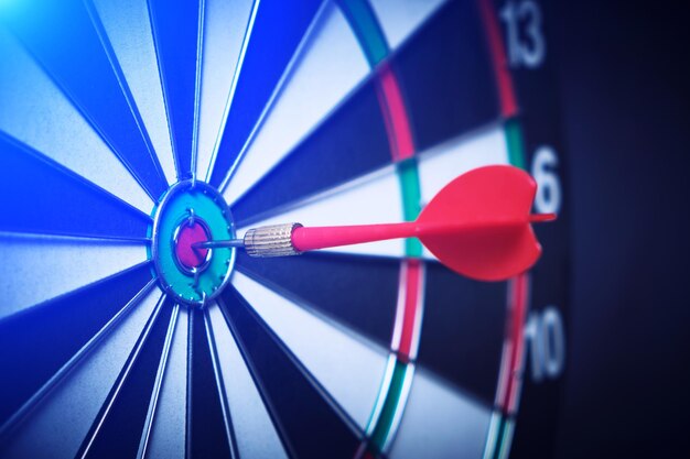 Concept d'atteinte de l'objectif D'atteinte d'objectifs dans les affaires et la vieDartboard avec flèche coincée à droite bullseye