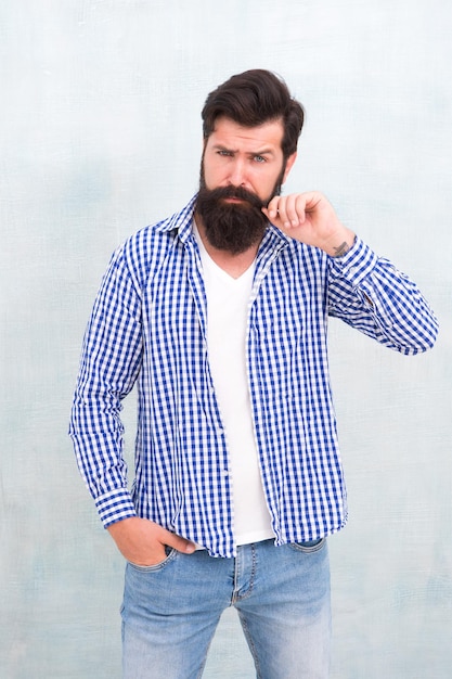 Concept d'attractivité Masculinité et beauté masculine Hipster avec barbe et moustache porter une chemise Gars bien soigné Brutal bel homme hipster fond de mur gris Homme barbu style hipster branché