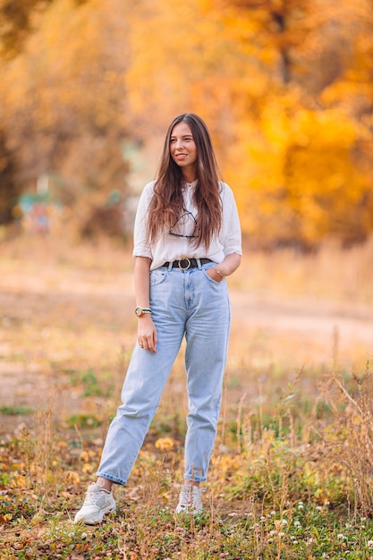 Concept d'automne - belle femme dans le parc d'automne sous le feuillage d'automne