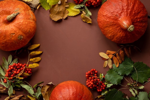 Concept d'automne avec une citrouille sur fond sombre avec des feuilles d'automne célébrant halloween et