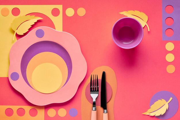 Photo concept d'automne à plat dans des couleurs vives avec assiette, fourchette, couteau et feuilles d'automne décoratives