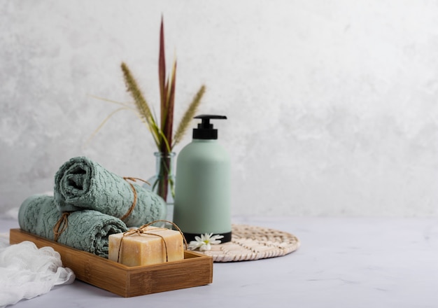 Photo concept de bain avec une bouteille de savon et des serviettes
