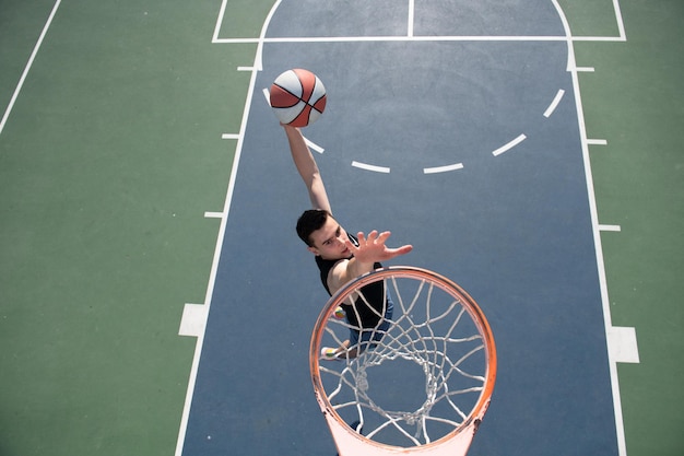 Concept de basket-ball homme sautant et faisant un slam dunk jouant au streetball basket urbain authentique