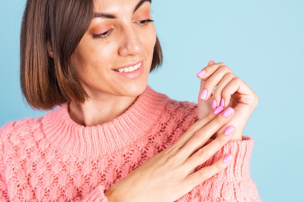 Concept de beauté, jolie femme avec manucure de couleur rose vif sur le mur