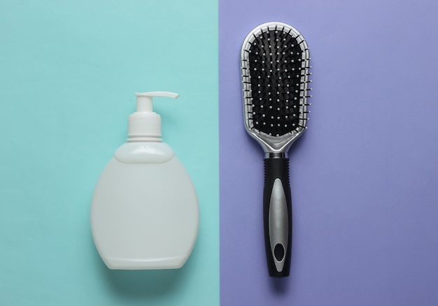 Concept de beauté minimaliste Peigne de soins capillaires et bouteille de shampooing sur fond bleu violet