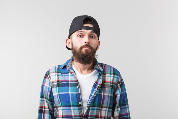 Concept de beauté, de mode et de personnes - Portrait d'un jeune homme élégant hipster barbu sur blanc