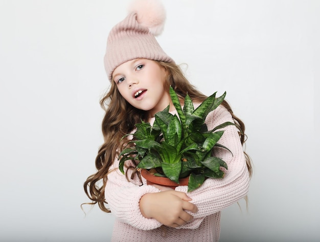 Concept de beauté et de mode Petite fille portant une tenue rose et tenant une fleur