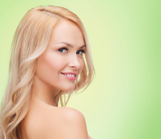 concept de beauté, de personnes et de santé - belle jeune femme aux épaules nues sur fond vert