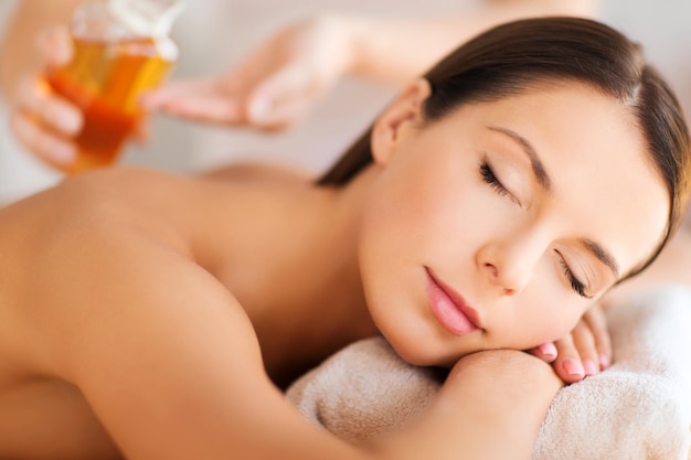 concept de beauté et de spa - belle femme dans un salon de spa recevant un traitement à l'huile