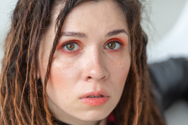 Concept de beauté, de style et de mode - Portrait de jeune femme belle avec un maquillage élégant et des dreadlocks.