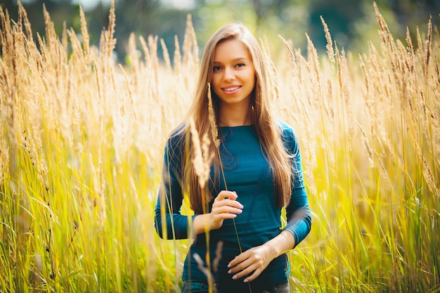 Concept - belle jeune fille blonde souriante de race blanche dans le champ