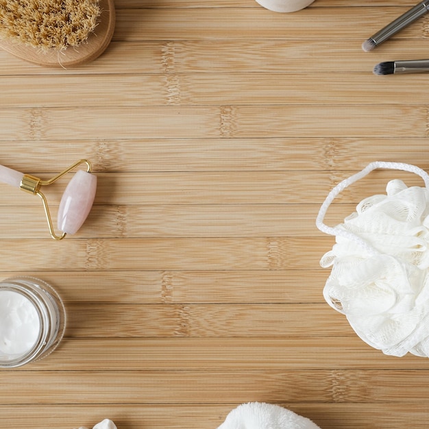 Concept de bien-être spa avec produits de bain sur fond en bois avec espace de copie Brosse éponge guasha Réglage de douche minimaliste esthétique