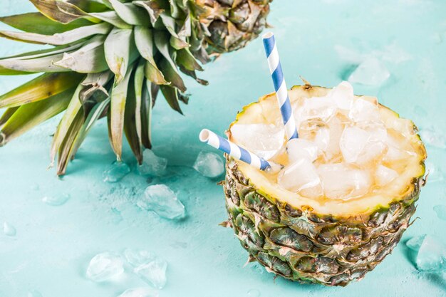 Concept de boisson d'été, cocktail d'ananas tropical ou jus à l'ananas avec de la glace, béton bleu clair