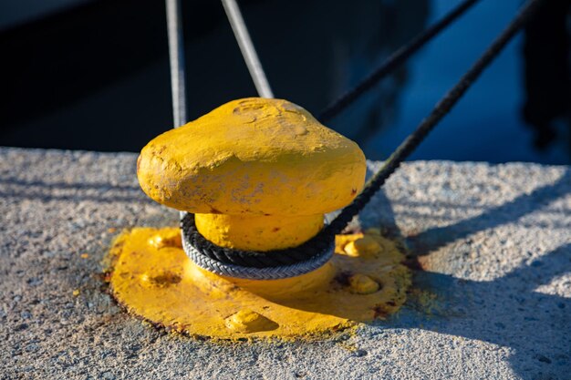 Concept de bollard d'amarrage Cordes torsadées avec boutons sur bollard métallique jaune