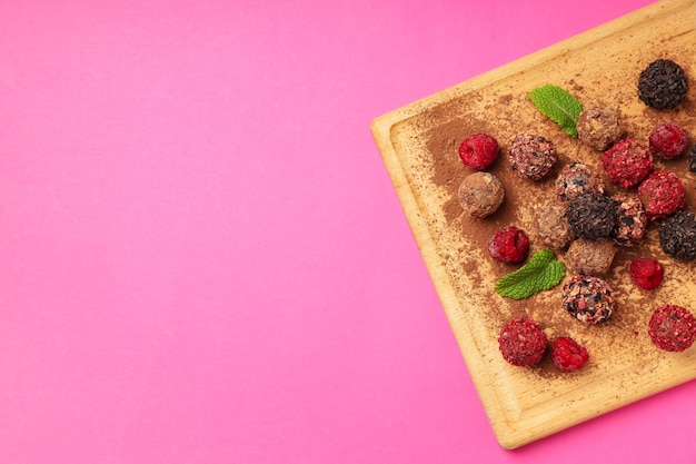 Concept de bonbons avec des bonbons au chocolat sur fond rose