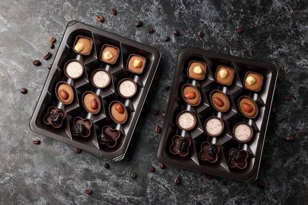 Concept de bonbons avec des bonbons au chocolat sur fond texturé sombre