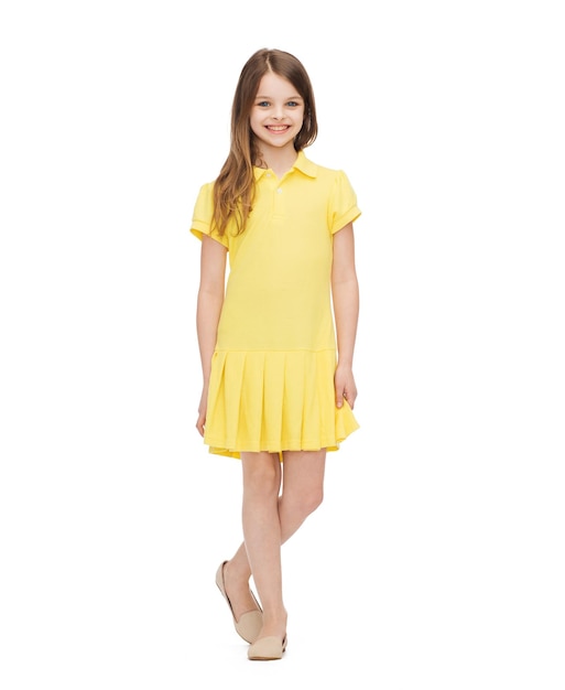 concept de bonheur, d'enfance et de personnes - petite fille souriante en robe jaune