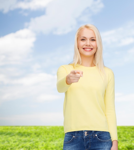 concept de bonheur, de geste et de personnes - femme souriante pointant le doigt vers vous