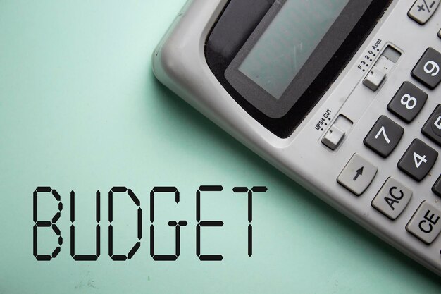 Concept de budget mensuel avec calculatrice grise sur fond vert