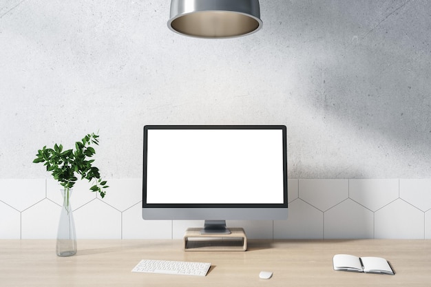 Concept de bureau à domicile avec écran d'ordinateur blanc vierge sur table en bois avec carnet de vase en verre et clavier dans une pièce ensoleillée avec maquette de rendu 3D de mur clair