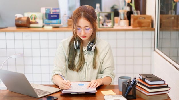 Concept de bureau d'espace de coworking Femme entrepreneur écrivant des données et lisant un document commercial