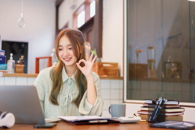 Concept de bureau d'espace de coworking Femme entrepreneur faisant un geste correct lors d'une réunion par appel vidéo