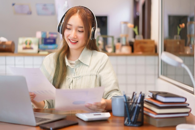 Concept de bureau d'espace de coworking Une femme entrepreneur se réunit par appel vidéo et lit un document