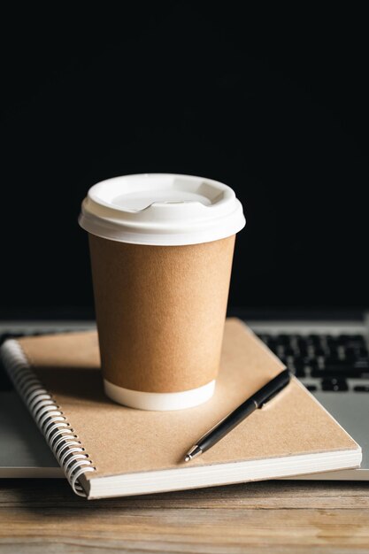 Concept de bureau à la mode Coupe de papier de café et carnet de notes recyclé sur clavier d'ordinateur portable