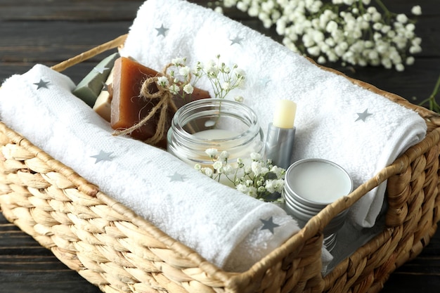 Concept de cadeau avec panier de cosmétiques sur fond de bois