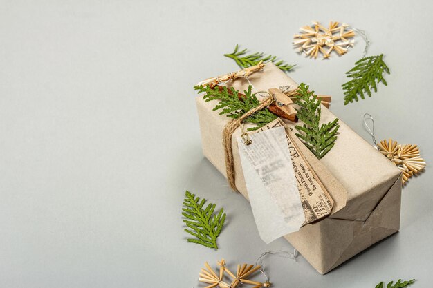 Concept de cadeau zéro déchet. Emballage écologique de Noël ou du Nouvel An. Boîtes festives en papier craft avec différentes décorations organiques. Fond gris clair, mise à plat, espace de copie